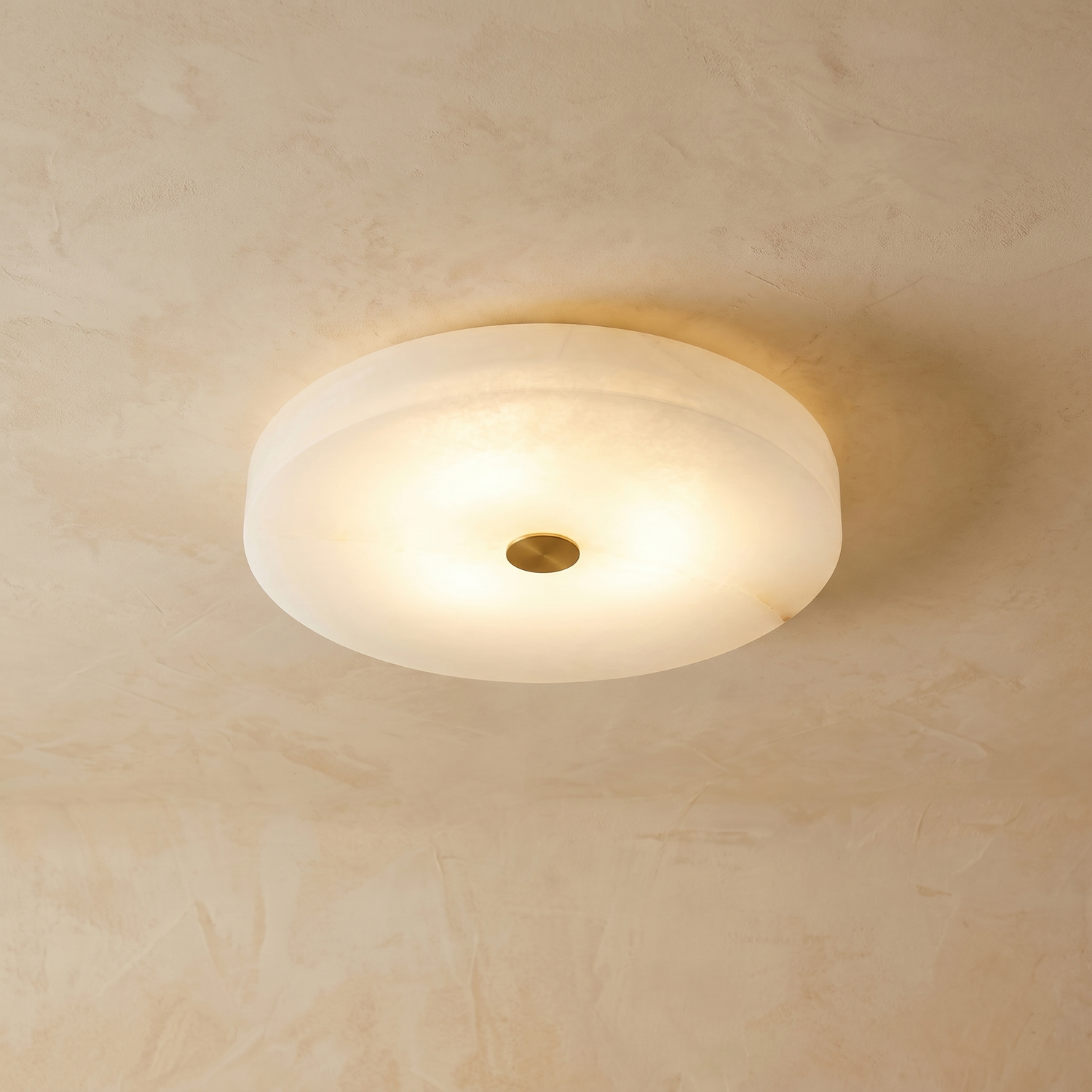 Orbita alabaster flush mount ceiling light on warm cream venetian plaster wall — modern hero shot