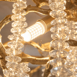 A Yiosi gold metal branch chandelier with cascading crystal beads suspended in a rainfall arrangement.