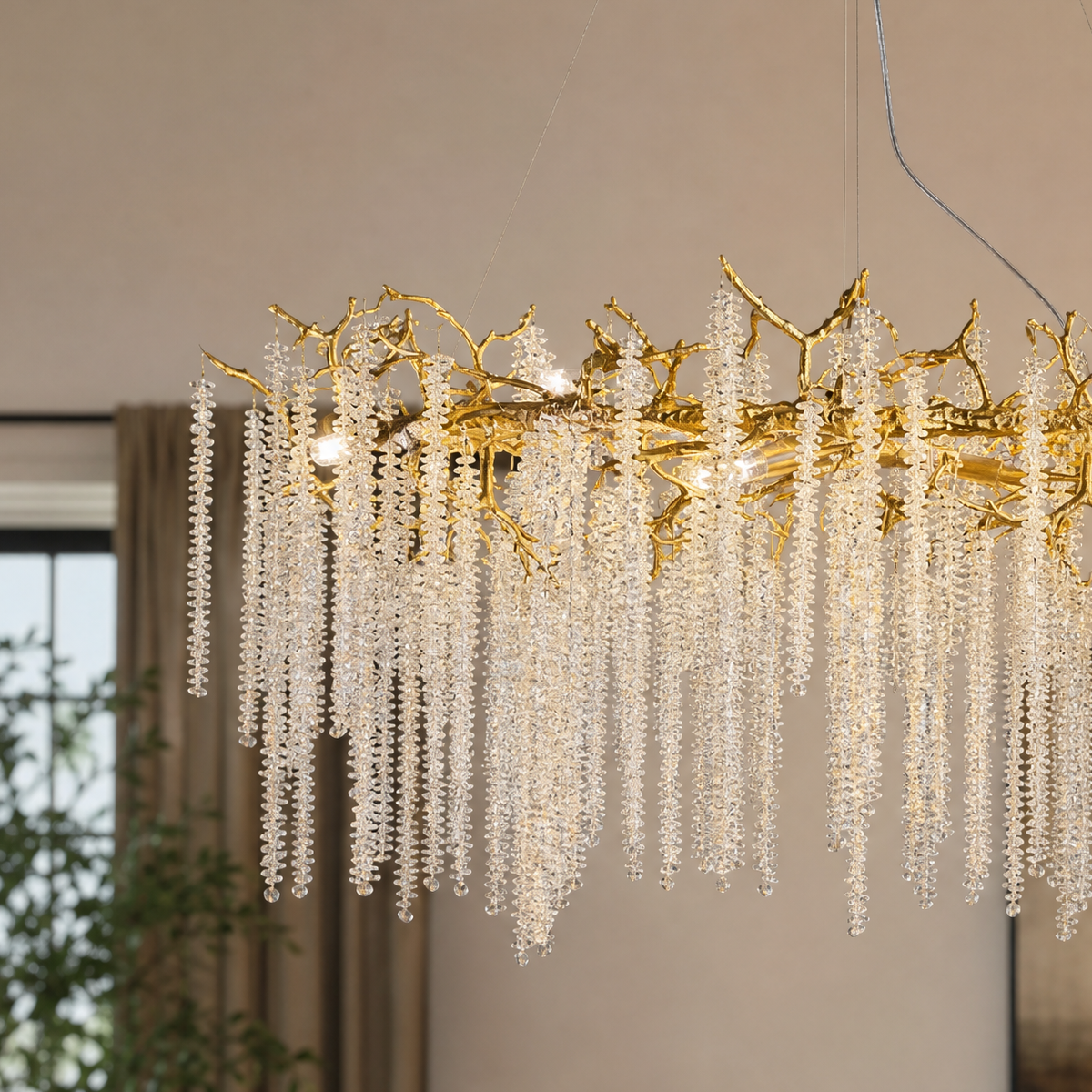 A Yiosi gold metal branch chandelier with cascading crystal beads suspended in a rainfall arrangement.