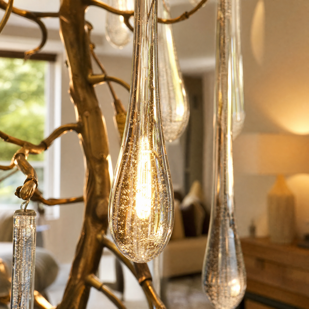 A tiered gold chandelier featuring cascading clear crystal icicle pendants suspended from a metallic branch-like frame.