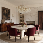 An antique brass branch chandelier adorned with hanging teardrop and icicle crystal pendants against a soft background.