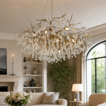 An antique brass branch chandelier adorned with hanging teardrop and icicle crystal pendants against a soft background.