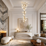 A brass branch-inspired chandelier featuring cascading frosted leaf-shaped glass shades hanging vertically.
