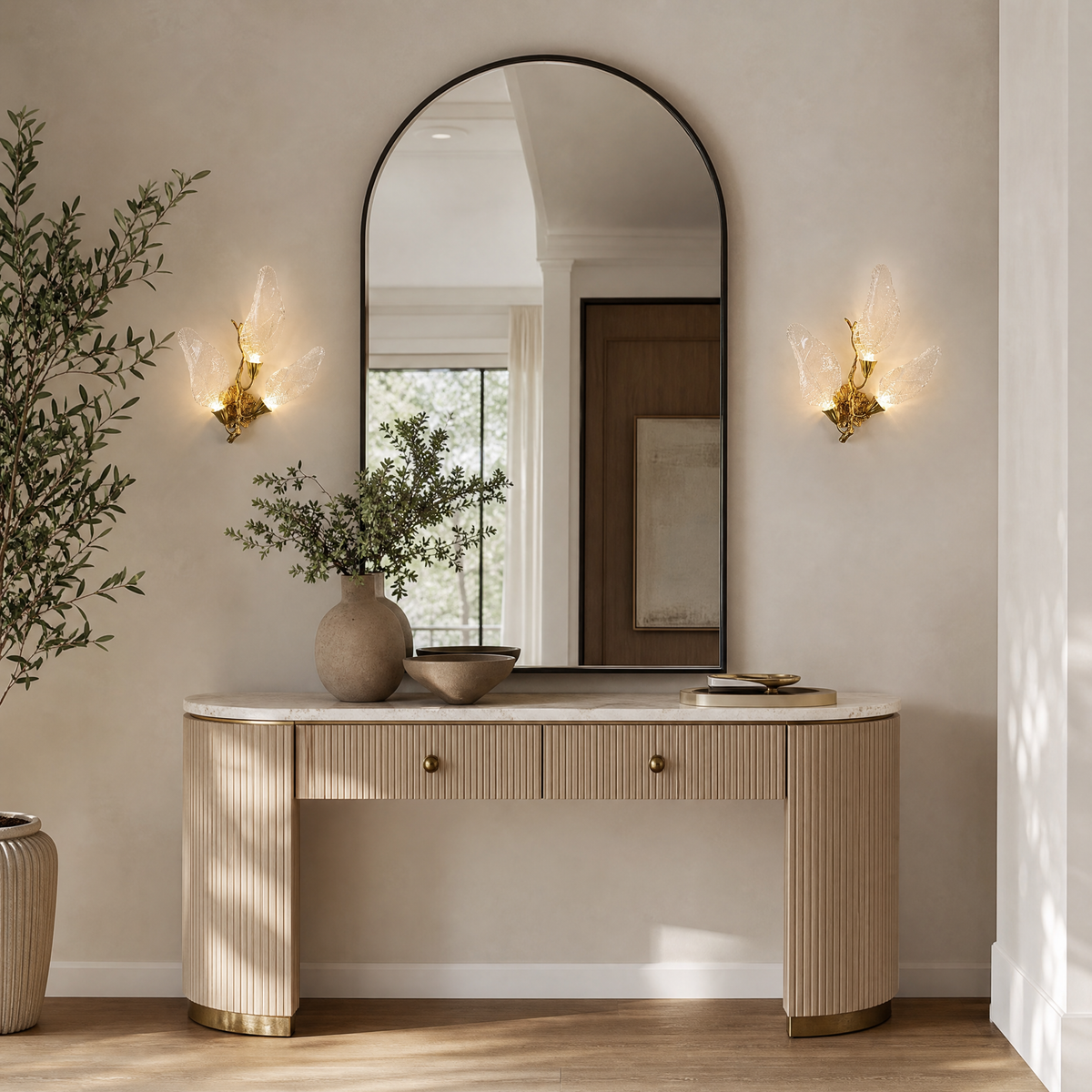 A wall sconce featuring sculpted leaf-shaped textured glass shades and a warm gold metal finish.