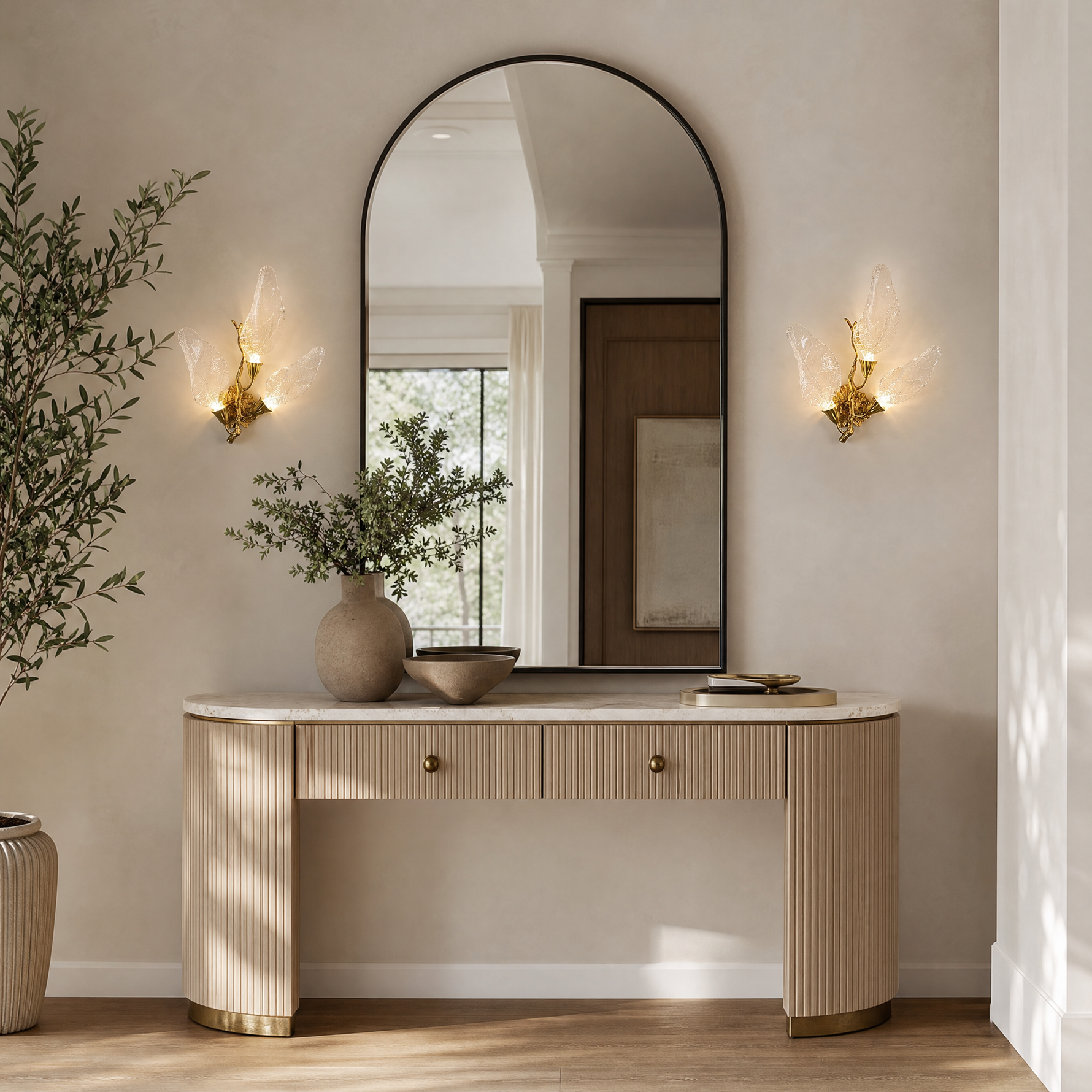A wall sconce featuring sculpted leaf-shaped textured glass shades and a warm gold metal finish.