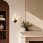 A wall sconce featuring sculpted leaf-shaped textured glass shades and a warm gold metal finish.