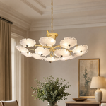 A tiered chandelier with a warm brass branch frame and petal-shaped frosted glass shades.