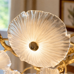 A tiered chandelier with a warm brass branch frame and petal-shaped frosted glass shades.