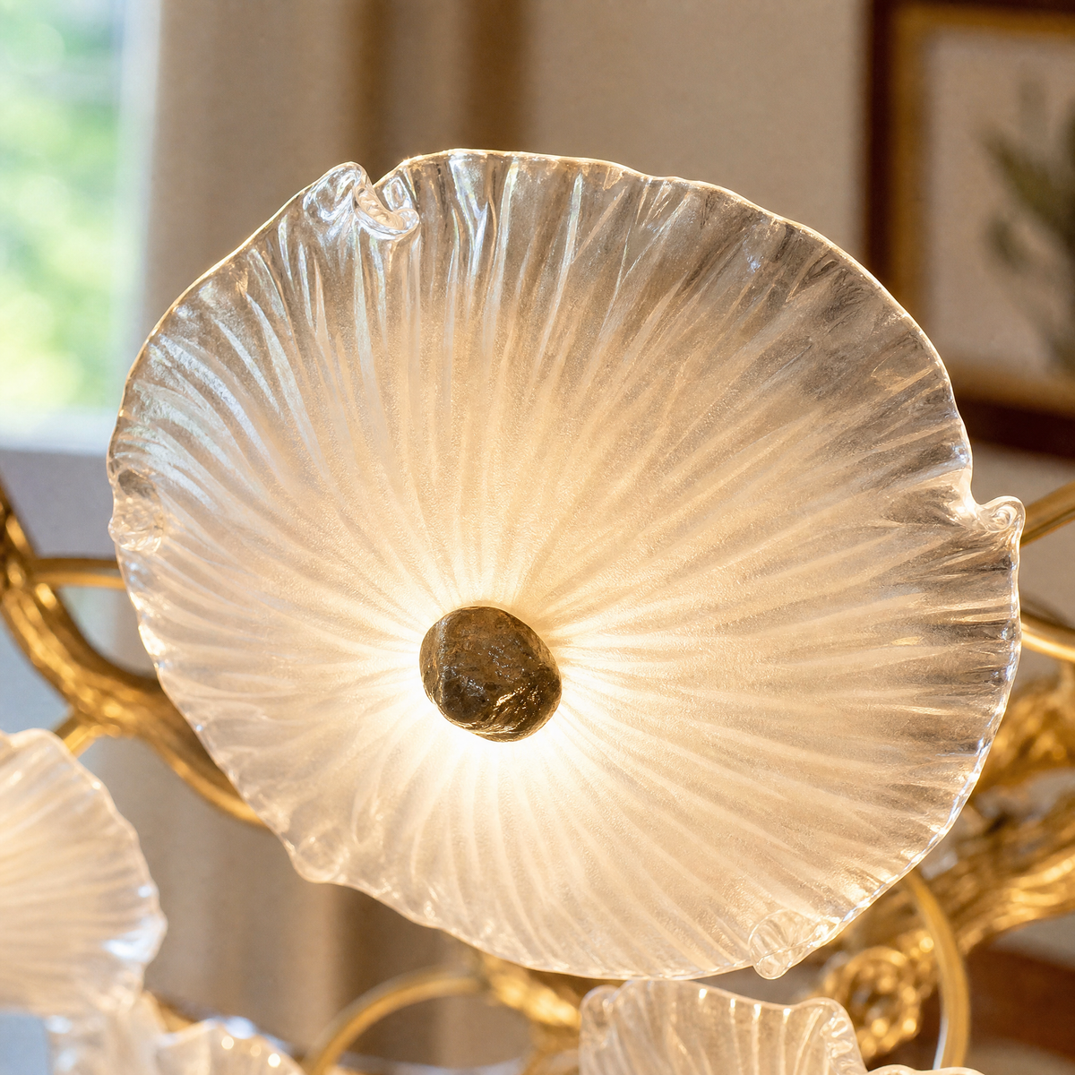A tiered chandelier with a warm brass branch frame and petal-shaped frosted glass shades.