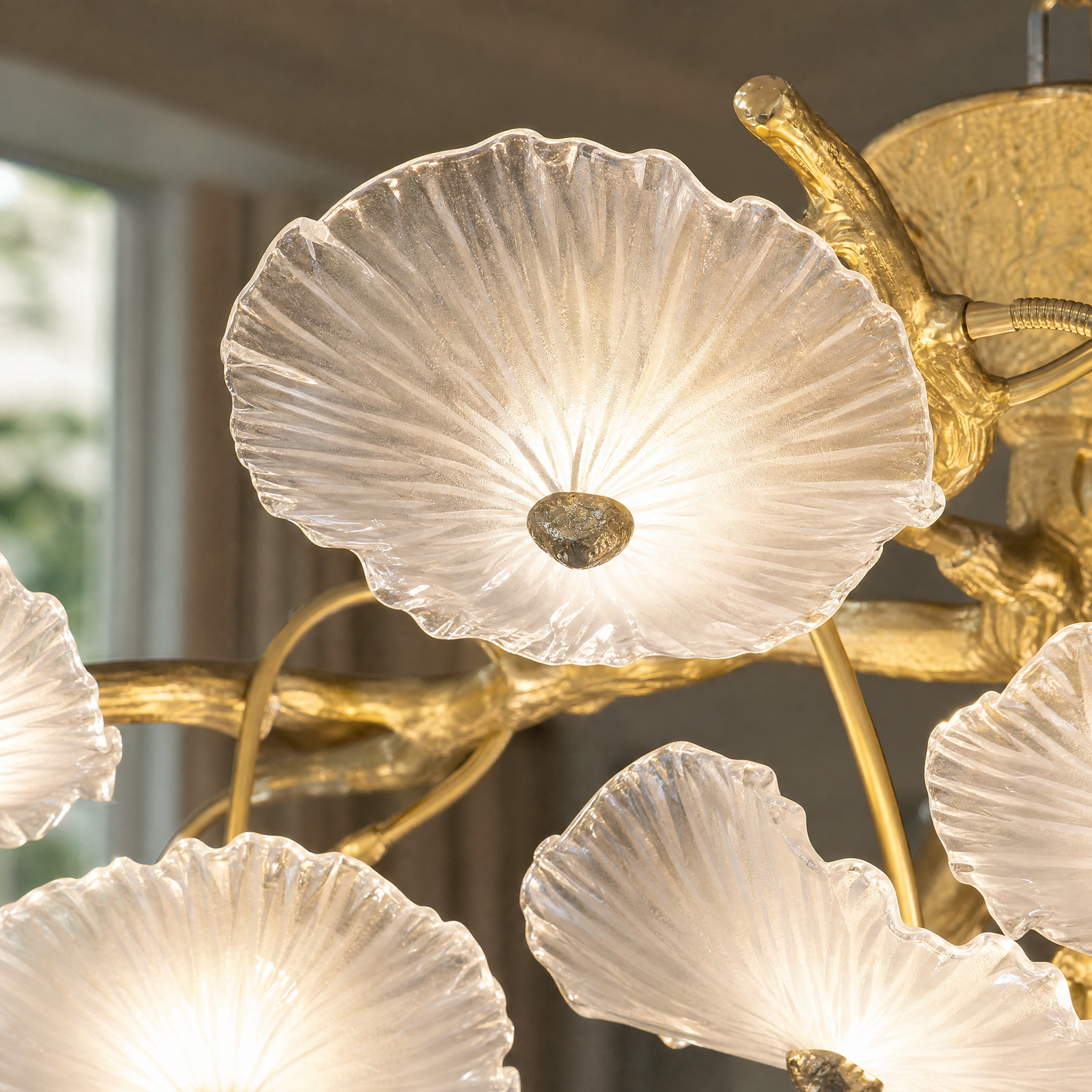A tiered chandelier with a warm brass branch frame and petal-shaped frosted glass shades.
