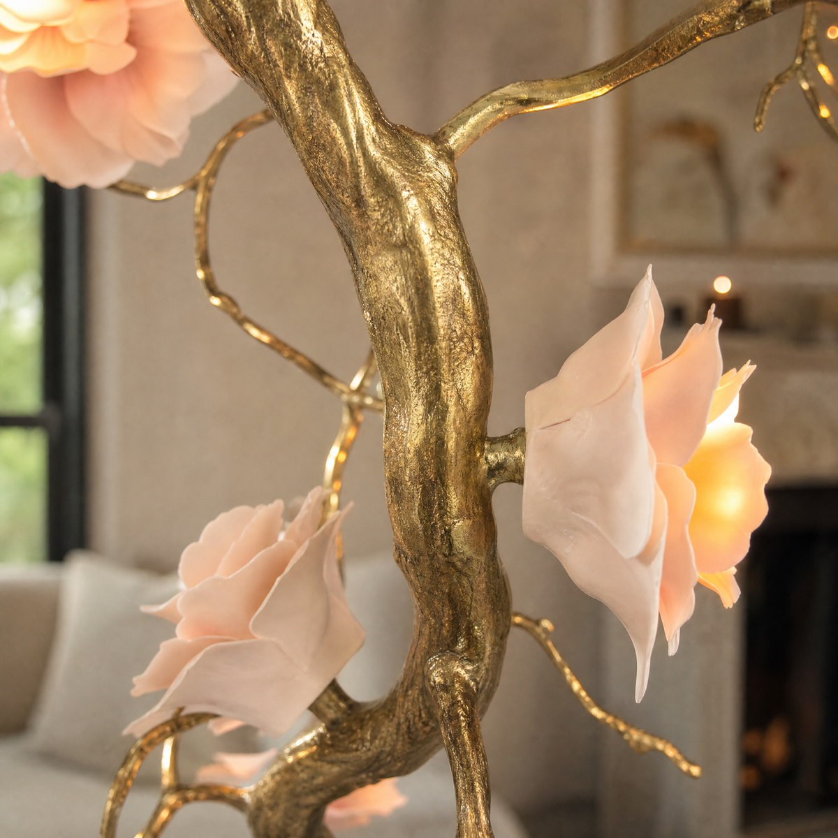 An antique brass branch chandelier with blooming floral glass shades suspended from a ceiling canopy mount.
