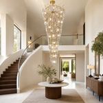 A gold metal branch frame supports a cascading waterfall of clear crystal teardrop prisms in this luxury chandelier.
