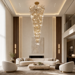 A gold metal branch frame supports a cascading waterfall of clear crystal teardrop prisms in this luxury chandelier.