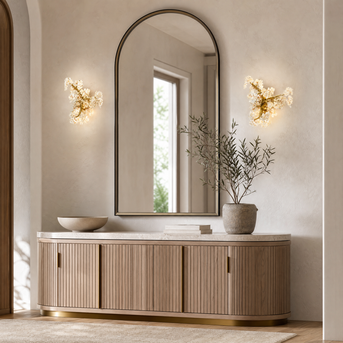 A sculptural wall sconce with a warm gold tree branch frame and faceted crystal floral clusters.