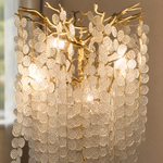 A gold metal tree floor lamp with cascading clear crystal drops standing on a square brass base.