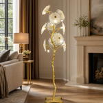 A Yiosi floor lamp with a gold brass organic branch stem and clear fluted glass flower petal shades.