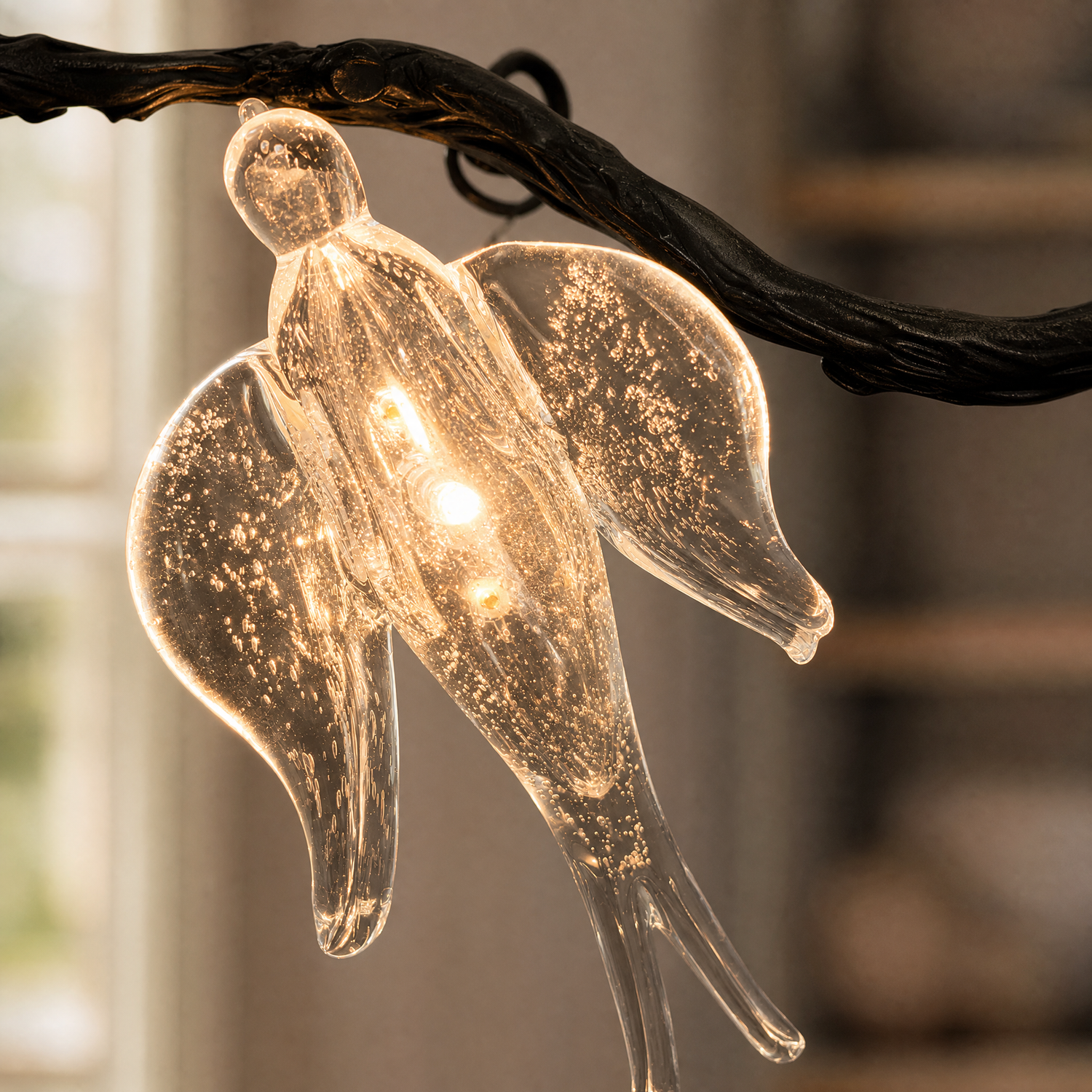 A modern wall sconce featuring a clear seeded glass bird perched on a textured black metal branch support against a plain