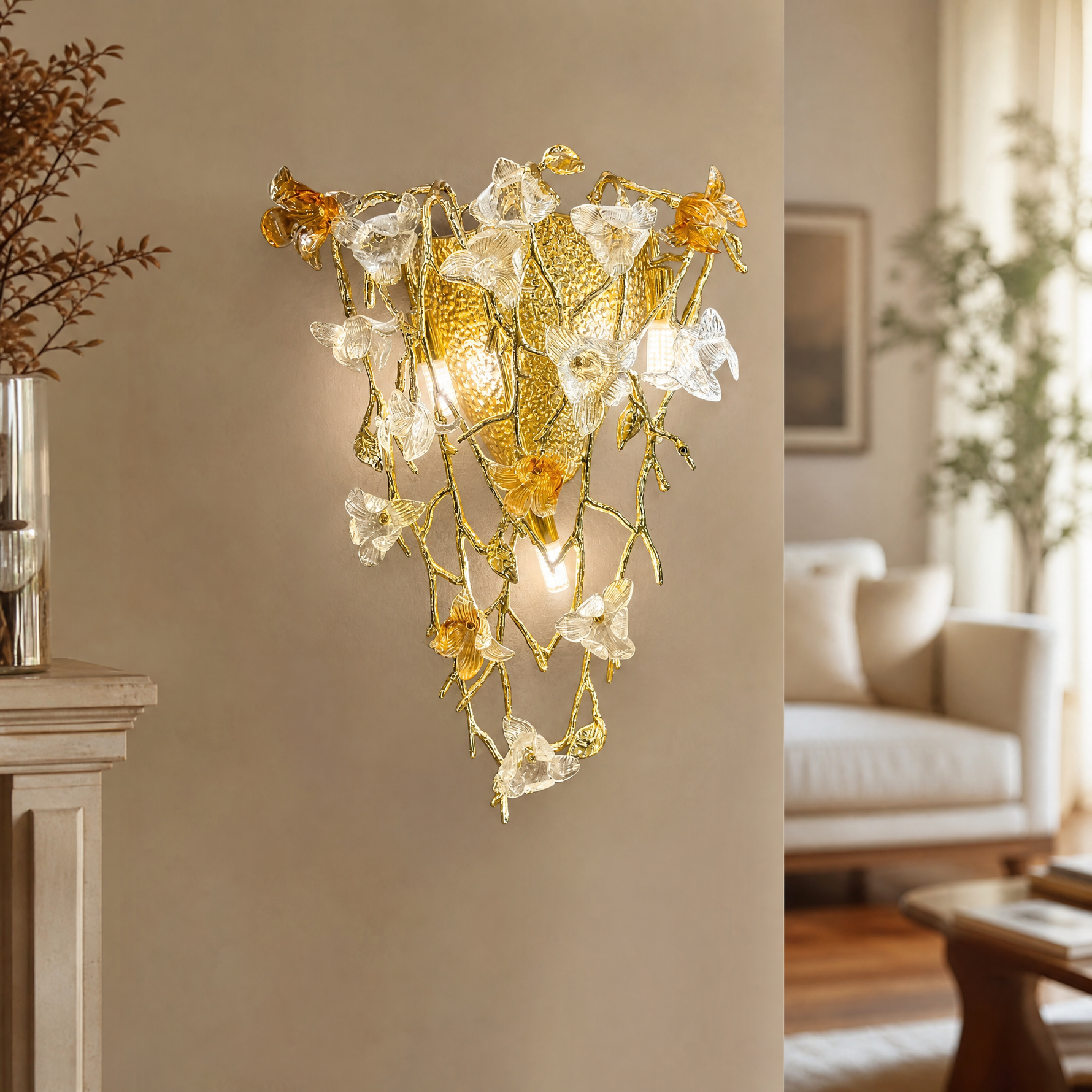 A gold metal wall sconce features a floral vine design with amber glass accents mounted on a wall.