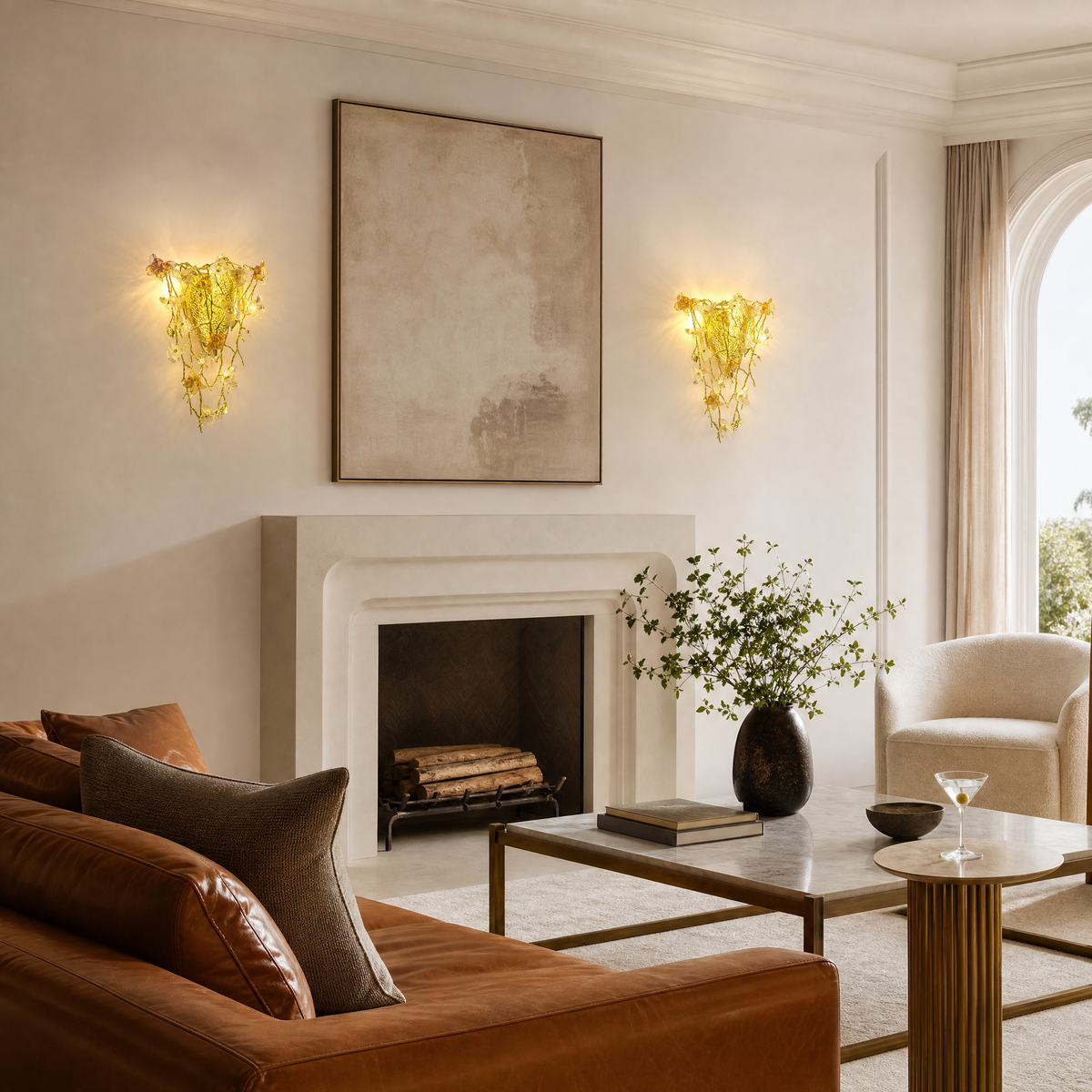A gold metal wall sconce features a floral vine design with amber glass accents mounted on a wall.