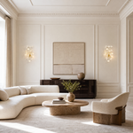 A wall sconce featuring white ceramic ginkgo leaf shades attached to a polished brass metal frame.
