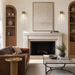 A textured gold metal wall sconce with organic branch accents and elongated fluted clear crystal pendants.