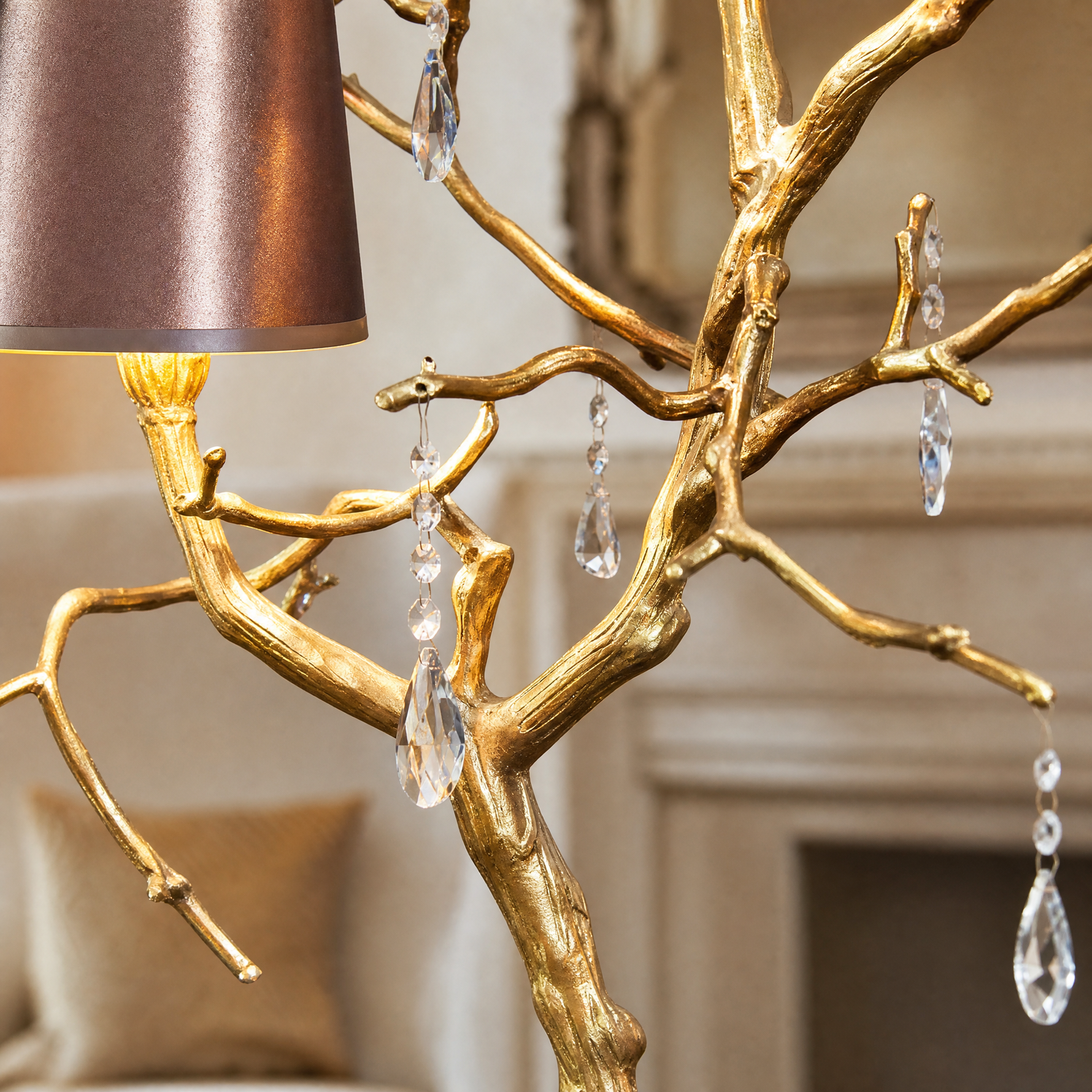 A decorative table lamp with a textured gold branch frame, hanging clear crystal droplets, and dual teal and purple shades.