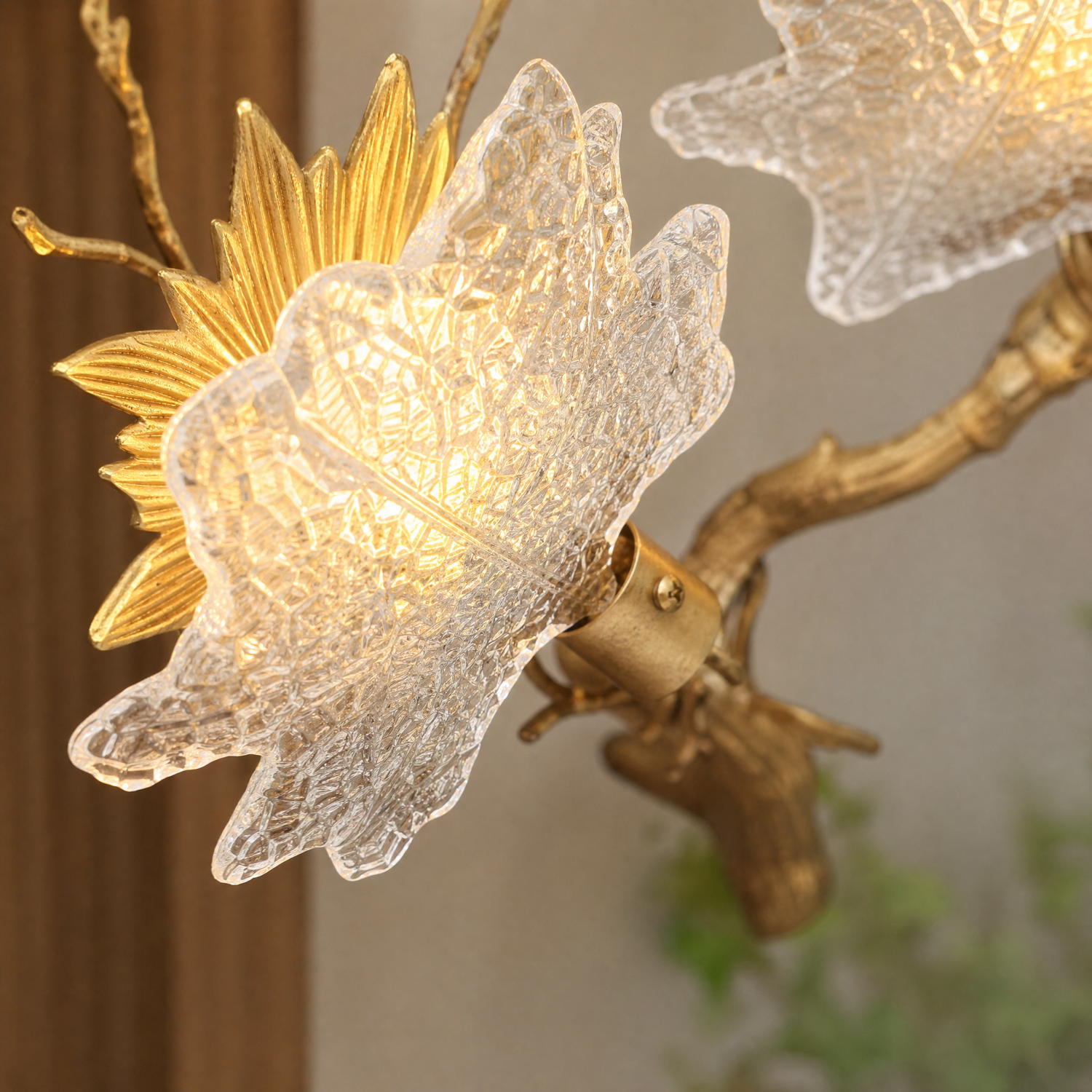 A Yiosi gold metal wall sconce featuring a maple branch design with three floral glass petal shades for ambient lighting.