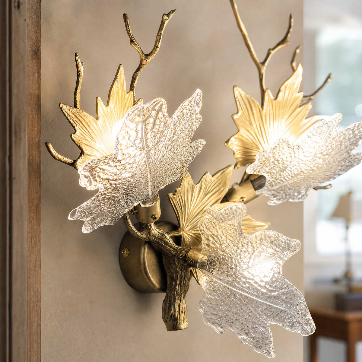 A Yiosi gold metal wall sconce featuring a maple branch design with three floral glass petal shades for ambient lighting.