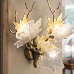 A Yiosi gold metal wall sconce featuring a maple branch design with three floral glass petal shades for ambient lighting.