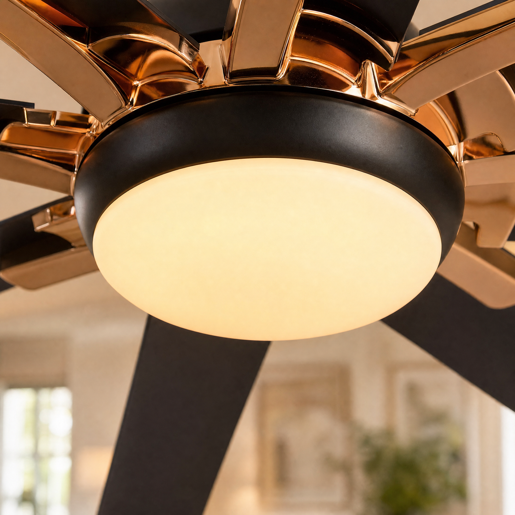 A modern eight-blade industrial ceiling fan with a matte black and rose gold finish featuring a center frosted LED light
