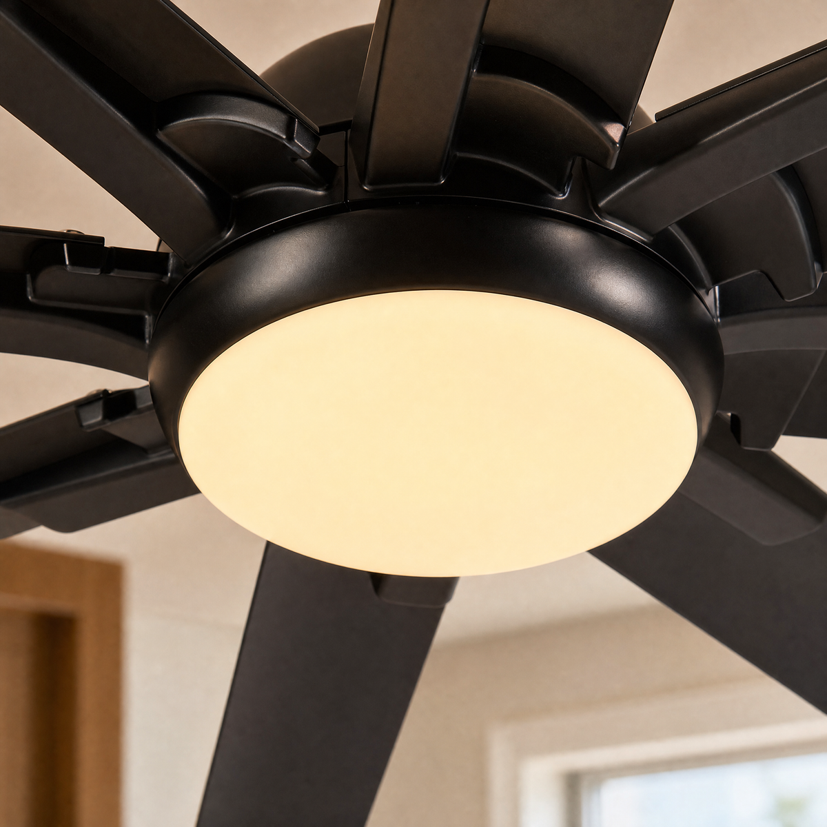 A modern eight-blade industrial ceiling fan with a matte black and rose gold finish featuring a center frosted LED light