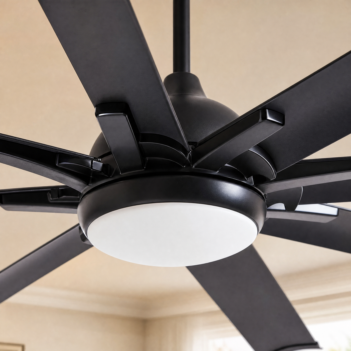 A modern eight-blade industrial ceiling fan with a matte black and rose gold finish featuring a center frosted LED light