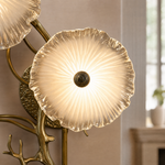 A contemporary wall sconce with three frosted glass discs clustered on a sculptural, branching arm with a warm brass finish.