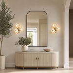 A contemporary wall sconce with three frosted glass discs clustered on a sculptural, branching arm with a warm brass finish.