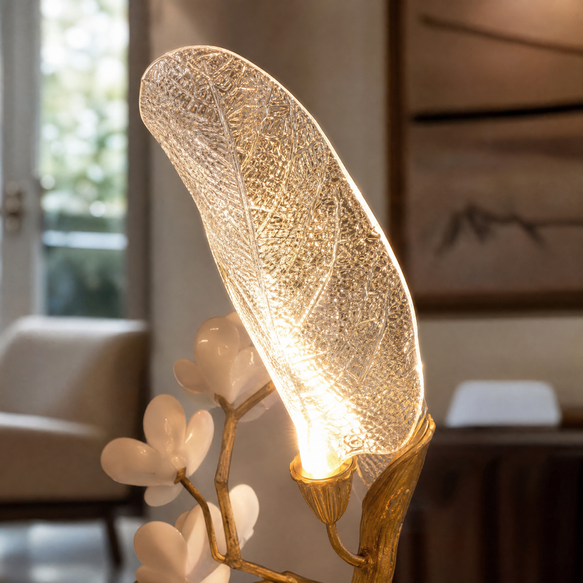 A sculptural floor lamp with a textured antique gold tree branch base and frosted glass leaf-shaped shades.