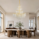 A large gold branch chandelier with tiered cascading crystal raindrop strands hangs against a neutral background.