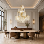 A large, multi-tiered chandelier with a gold branch-like frame and long strands of cascading crystal droplets.