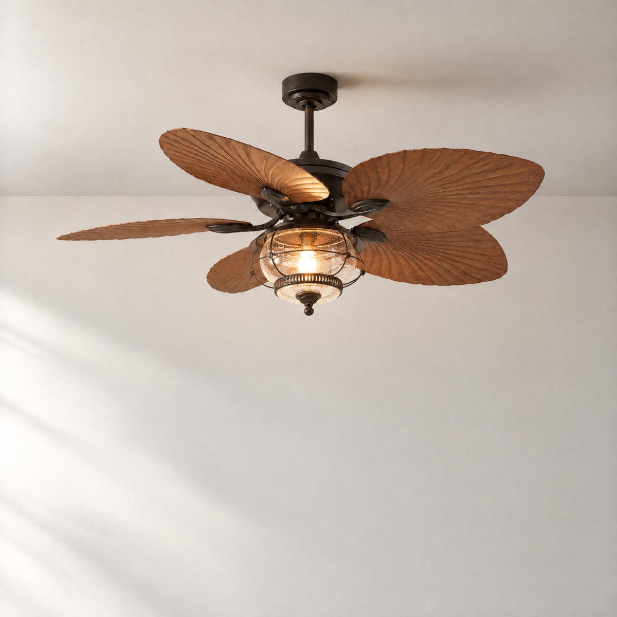 Bronze Palm Leaf Ceiling Fan with Caged Seeded Glass Light – lights on