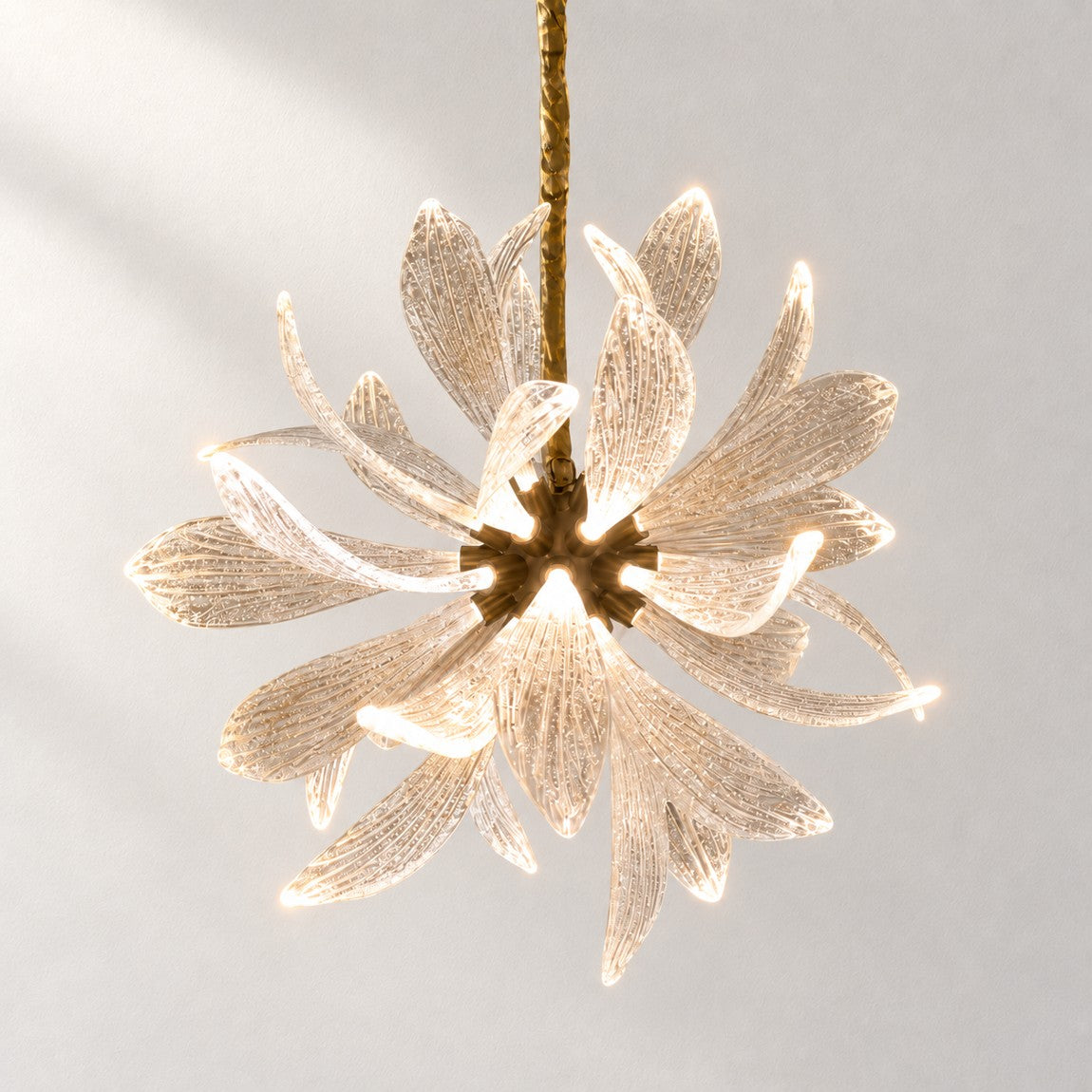 Crystal Chandelier Organic Modern Brass Textured Glass for Dining Room on a light warm plaster wall