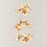 Gold Chandelier Cascading Glass Flower Metal 28.3"L × 108.3"H for Dining Room on a light warm plaster wall