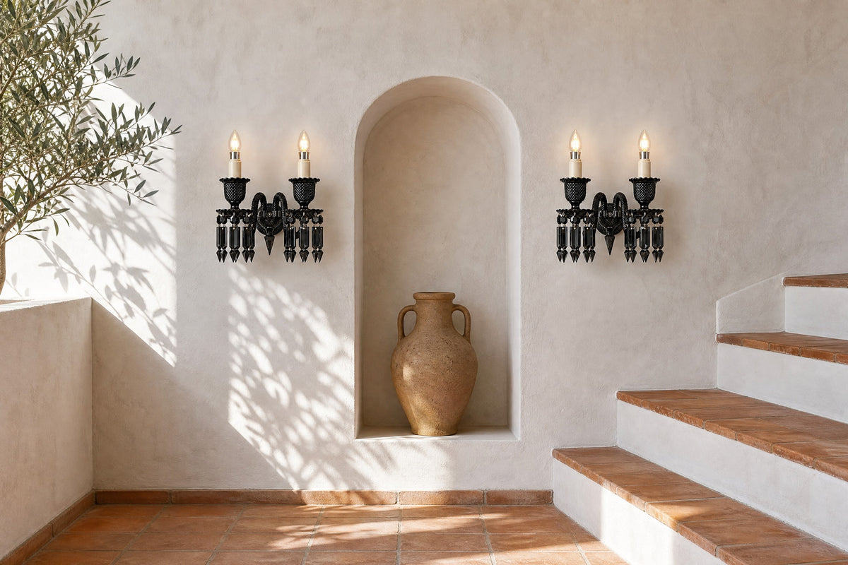 Pair of Palvera black prism crystal two-light wall sconces either side of an arched niche with a clay amphora on a whitewashed stair landing with terracotta steps