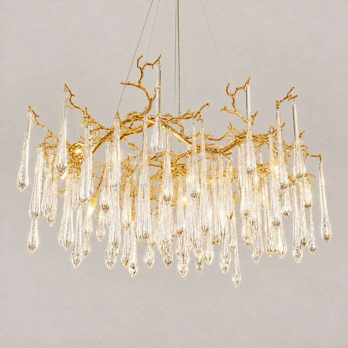 Modern Chandelier Gold Branch Metal Glass Droplets 18-Light for Dining Room Living Room on a light warm plaster wall