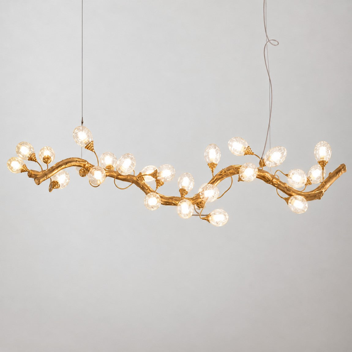 Modern Chandelier Organic Modern Textured Gold Glass 24-Light for Dining Room on a light warm plaster wall