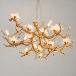 Modern Chandelier Organic Modern Textured Gold Glass Flower 12-Light for Dining Room on a light warm plaster wall