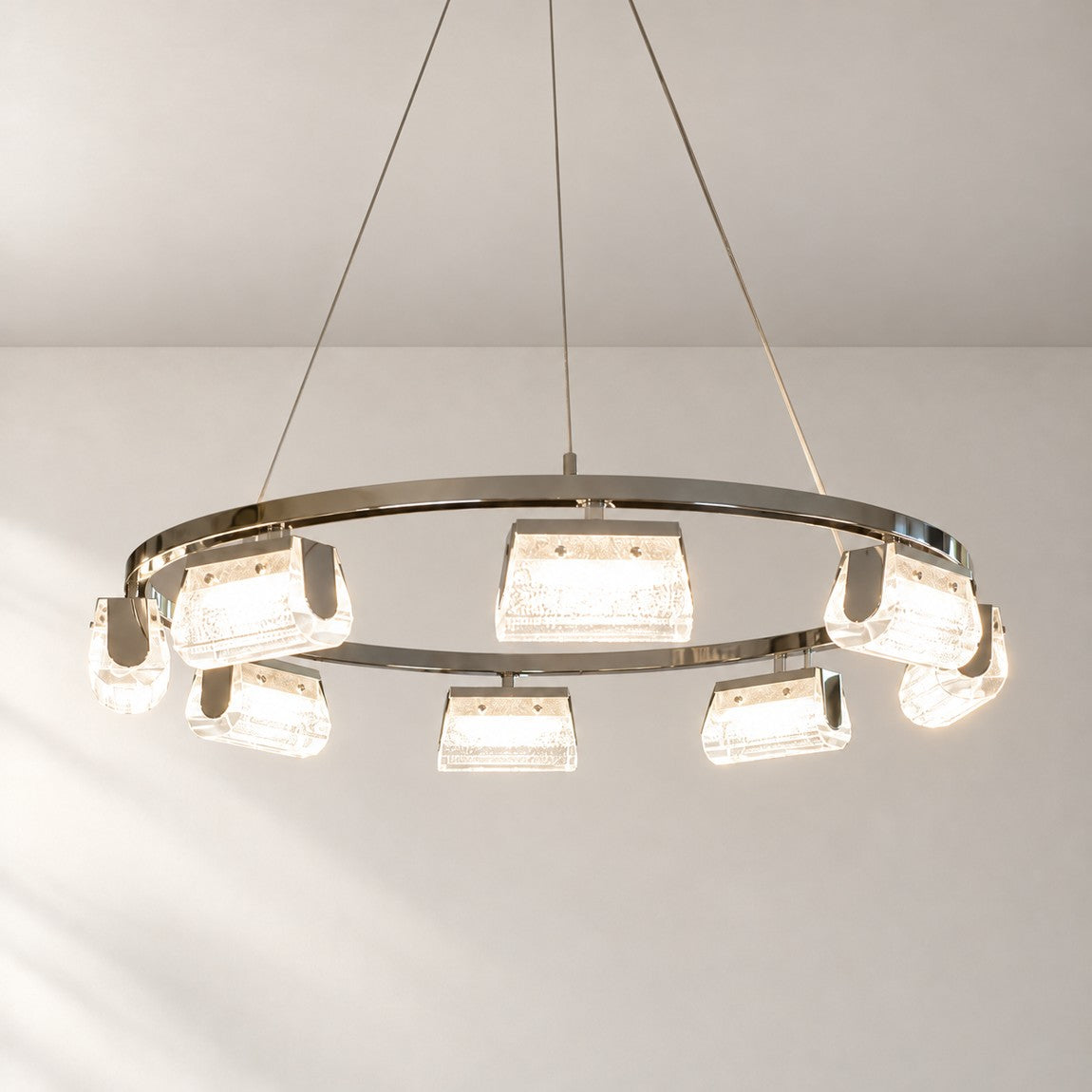 Modern Chandelier Polished Chrome Ring Textured Glass for Dining Room on a light warm plaster wall