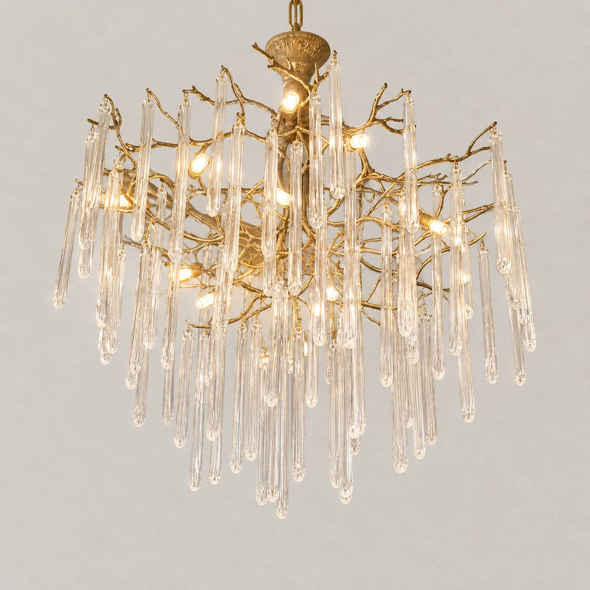 Modern Chandelier Textured Gold Glass Drops 15-Light for Living Room on a light warm plaster wall