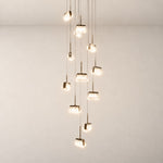 Modern Pendant Light Light Gold Metal K5 Crystal 13-Light for Staircase Foyer on a light warm plaster wall