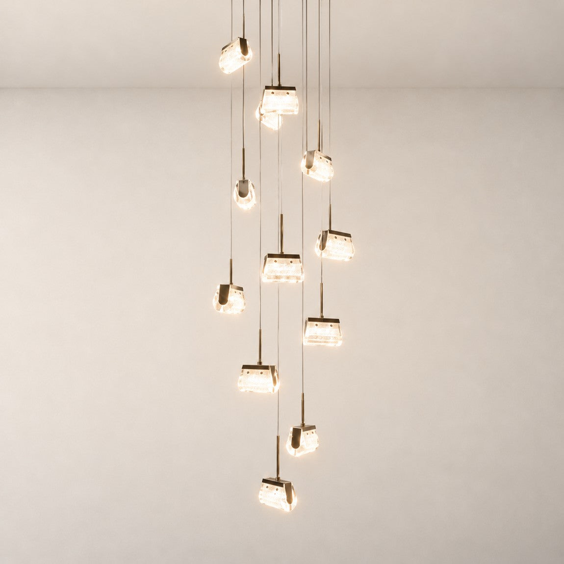 Modern Pendant Light Light Gold Metal K5 Crystal 13-Light for Staircase Foyer on a light warm plaster wall
