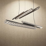 Yiosi Drake 63 inch linear crystal chandelier in modern American dining room with warm ambient glow