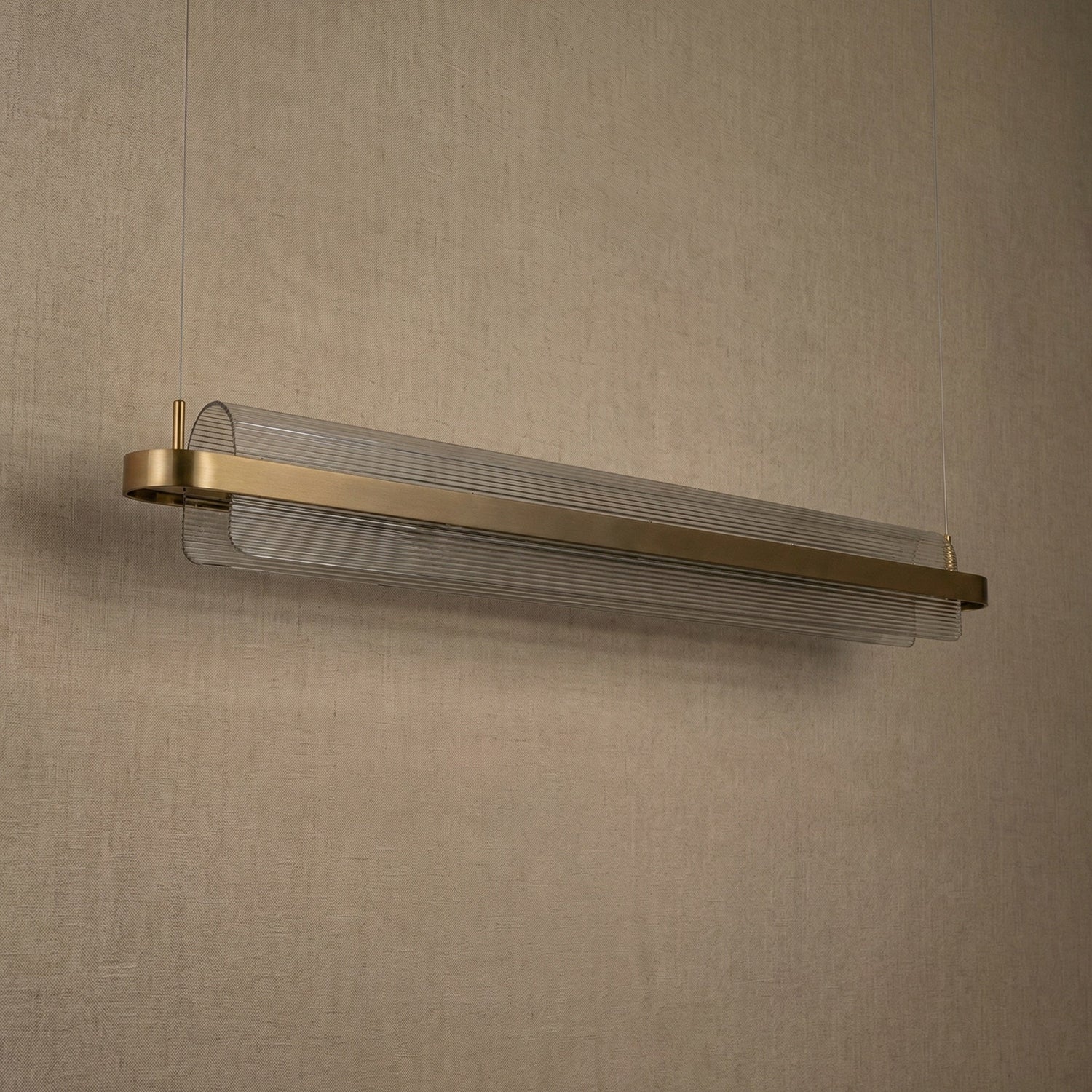 Acrylic ribbed linear pendant over kitchen island marble countertop — Yiosi Ribbon chandelier